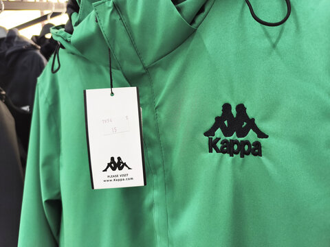 Green kappa jacket with logo and price tag in clothing store display