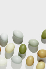 Pattern of natural colored chicken Eggs with sun shadows, minimal style aesthetic holiday background, organic dyed eggs foe easter celebration, minimalist food composition, pastel colored