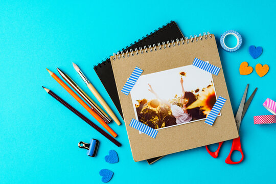 Creative workspace with craft supplies and a photo of a joyful event on a bright blue background