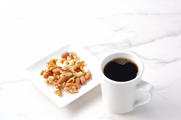 栄養たっぷりのミックスナッツと、淹れたてで香りのよいコーヒー
