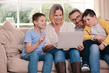 Happy, laptop and parents with children on sofa for watching movies, online games and streaming...