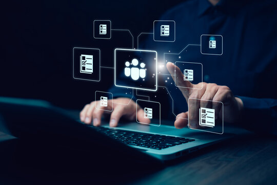 Digital human resource management concept. A businessman interacts with a virtual HR system, managing employee data, recruitment, and task automation through a futuristic interface on a laptop.