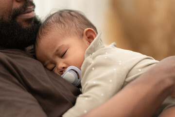 A little boy sleeps in his father's arms