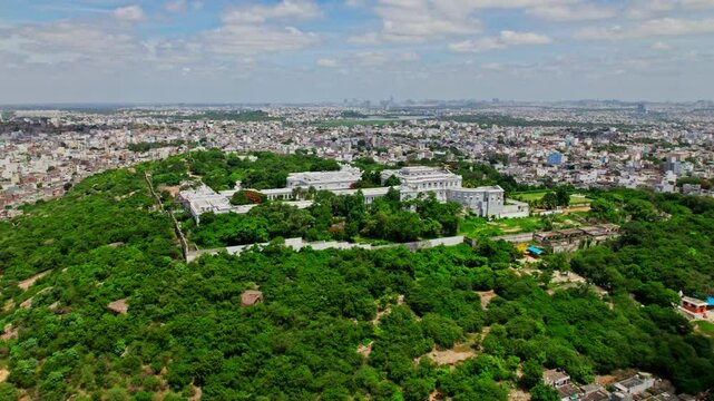 Taj falaknuma palace with background crowded building, trees, sky and clouds at engine bowli, falaknuma, hyderabad, telangana, india. day time, push in, drone shot, 4k.