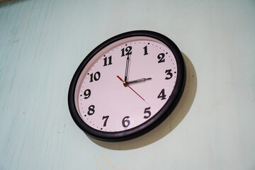 A classic analog wall clock showing the time, a simple and elegant design on a wall. Classic Wall...