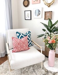 White Chair With Teal And Coral Patterned Pillows