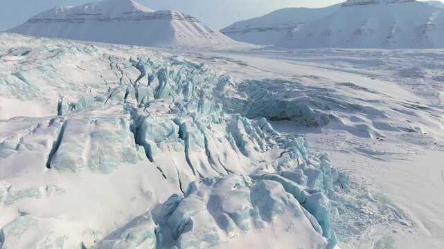 Arctic circle endless frozen landscape with heavy snow on mountains and glaciers, Aerial view