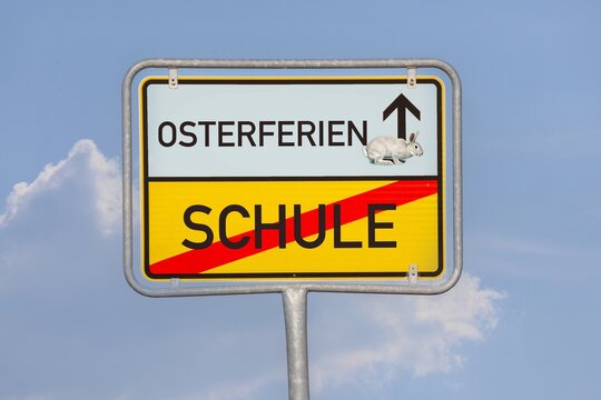(Fotomontage) Osterferien Schule: Auf einem Ortsausgangsschild stehen die Worte OSTERFERIEN und SCHULE