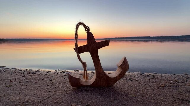 beautiful wooden anchor on romantic beach in sunset