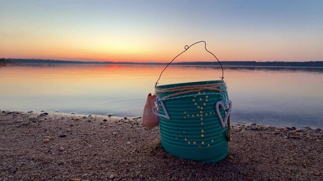 burning candle in a rustic can on the romantic beach