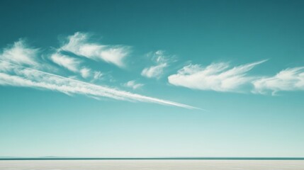 Wispy clouds stretch across a serene sky above an endless horizon, evoking boundless peace and infinite possibilities.