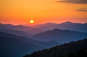 Fototapeta premium Sunset over the Carpathian Mountains, silhouettes of hills and forests against an orange sky with the sun setting in view. The mountains cover most of the frame sunset in the mountains