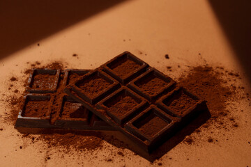 A bar of chocolate on a brown background.  茶色背景上に置かれた板チョコ