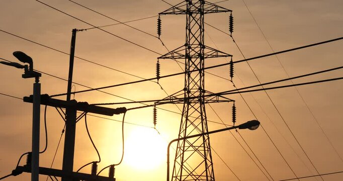 Sunset Power Lines: Silhouetted power lines and transmission towers stand tall against a vibrant sunset, conveying themes of energy, infrastructure, and the connection between nature and technology.