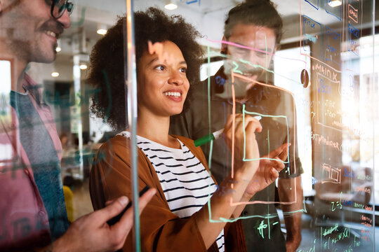 Group of business people and software developers working as a team in modern startup office