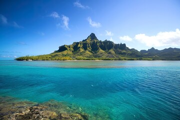 Fototapeta premium A tropical island with a mountainous landscape surrounded by clear turquoise waters
