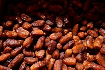 Close-up of dates, an indispensable part of Ramadan tables. Dates are in piles. Ramadan, fasting, holidays, worship.