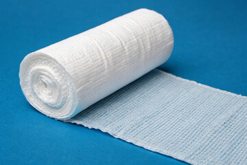 Fototapeta premium A sterile bandage roll on a blue background.