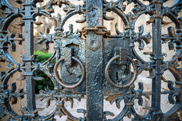 Close-Up of an Old Metal Gate with a Lock on Sveti Stefan Island, Montenegro. A Historic and Weathered Entrance