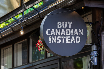 BUY CANADIAN INSTEAD. Round, black sign onn teh wall of the house