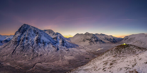 View into Glencoe, Highlands, Scotland. A lone tent wild camping on the peak over looking Glencoe at sunset.