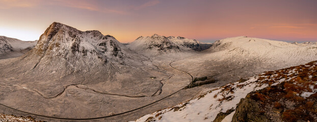 View into Glencoe, Highlands, Scotland. A lone tent wild camping on the peak over looking Glencoe at sunset.