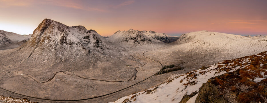 View into Glencoe, Highlands, Scotland. A lone tent wild camping on the peak over looking Glencoe at sunset.
