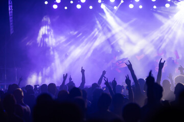 Crowd at concert and colorful stage lights.