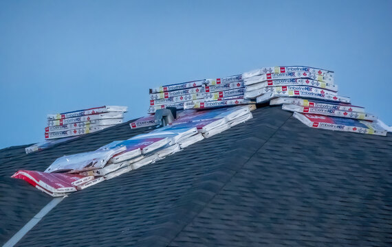 Calgary, Alberta, Canada. Feb 2, 2025. Roofing job in progress: Timberline HDZ shingles stacked on a new roof. Construction, home improvement, materials.