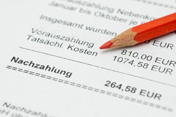 Ein Rotstift liegt auf einer Nebenkostenabrechnung f&uuml;r eine Mietwohnung mit Berechnung des pers&ouml;nlichen Verbrauchs und einer Nachzahlung - Symbolbild