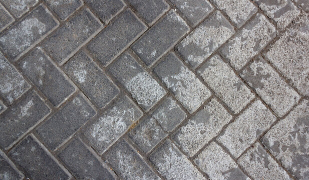 Interlocking Gray Paving Blocks in a Herringbone Pattern