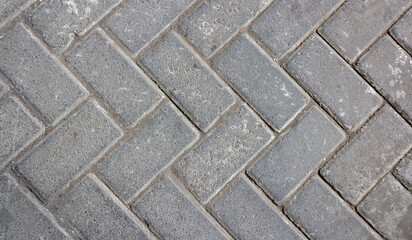 Interlocking Gray Paving Blocks in a Herringbone Pattern