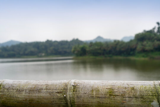 empty bamboo table with blurry lake background