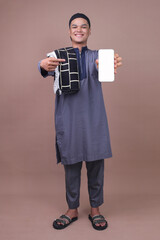 Full Length Shot Of Young Asian Muslim Man Showing Blank Screen Smartphone Isolated On Beige Background 