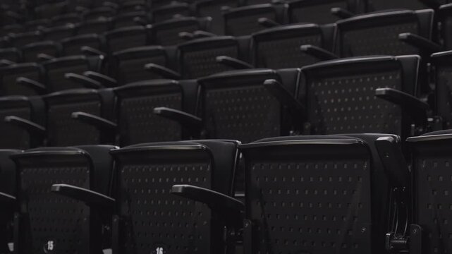 Pan shot across folded tiered seating inside empty stadium arena venue