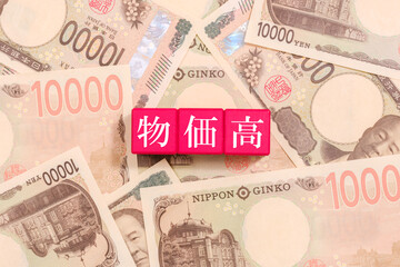 一万円札とブロックの上に書かれた物価高　経済