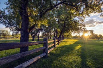Serene Landscape at Sunset with Golden Sunlight Filtering Through Trees and Fencing in a Peaceful Meadow Setting
