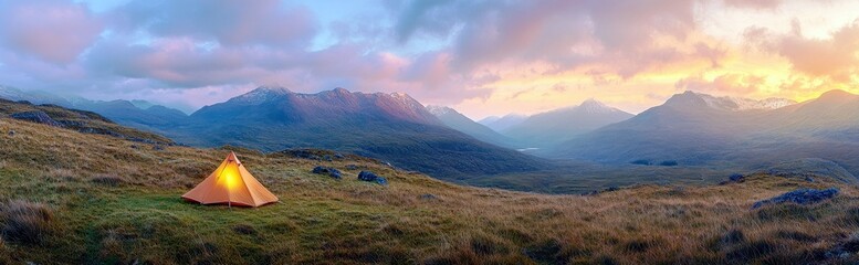 Naklejka premium Serene campsite with glowing tent in a breathtaking mountain landscape at sunset surrounded by lush greenery and majestic peaks on a calm evening