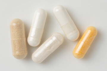 Macro Shot of Various Dietary Supplement Capsules on White Background
