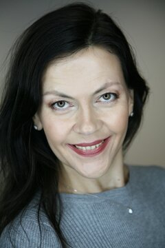 Portrait of smiling cheerful happy middle-aged brunette woman 51 years old with evening make-up and natural hair styling