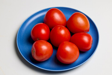 whole fresh tomatoes on a plate