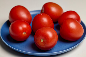 whole fresh tomatoes on a plate