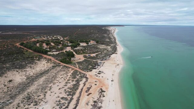 Aerial view of beautiful Nanga Bay with sandy beach and clear ocean, Denham, Australia.