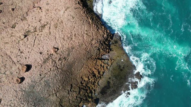 Aerial view of rugged cliffs and crashing waves at Quobba blowholes, Point Quobba, Gascoyne Region, Australia.