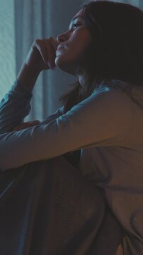 Unhappy woman in bed at night
