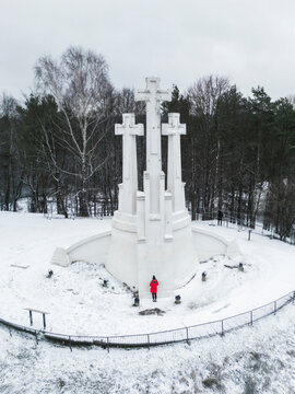 Aerial view of three crosses monument surrounded by snow-covered trees in winter, Vilnius, Lithuania.