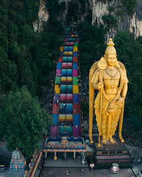 Aerial view of the colorful Batu Caves with the towering statue of Murugan and historic temple steps, Batu Caves, Malaysia.