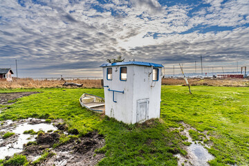 Small Coastal Shed and Boat on Grass Under a Cloudy Sky, Hjarnoe, Denmark