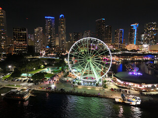 Aerial view of vibrant downtown miami skyline with illuminated skyscrapers and ferris wheel at night, florida, united states.
