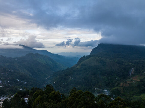 Aerial view of majestic mountains and a tranquil valley surrounded by clouds, Ella, Sri Lanka.